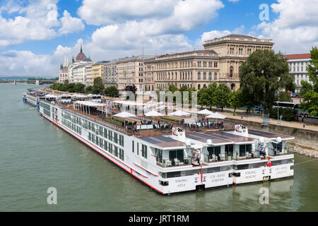 Viking River Cruises cruise barche ormeggiate sul lato Pest del Danubio con il palazzo del Parlamento in distanza, Budapest, Ungheria Foto Stock