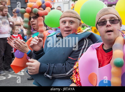 62/150 didascalia due sindrome di Down gli uomini guardano a lui la fotocamera a Stockton International Riverside Festival parade Foto Stock