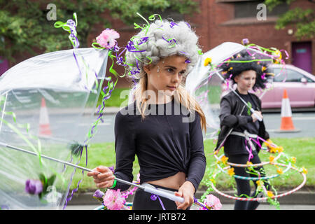 Didascalia 62/150 una ragazza giovane con ombrellone e fiori a Stockton International Riverside Festival parade Foto Stock