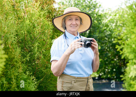 Felice Senior donna fotografare in vacanza Foto Stock