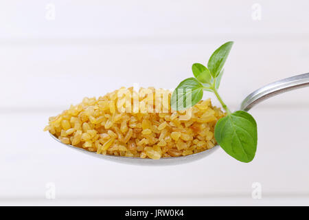 1 cucchiaio di estratto secco di Bulgur di grano bianco su sfondo di legno Foto Stock
