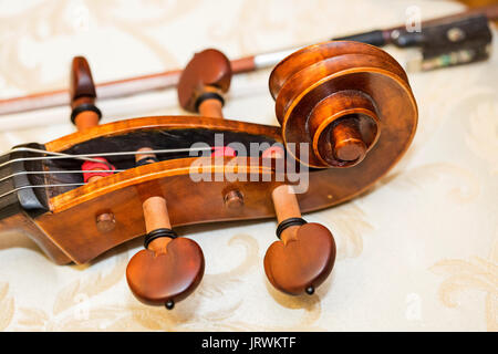 Tastiera di contrabbasso, gli strumenti a corda concetto - close-up sulla chiocciola di contrabbasso, musica classica orchestra, violino, testa, dado, teste di macchina, collo, stringa, macro. Foto Stock