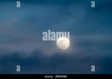 Luna in waxing gibbous fase e blu scuro nuvole serali Foto Stock