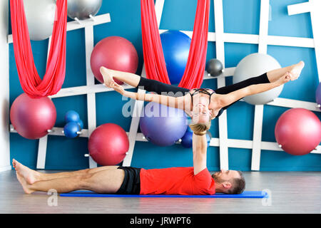 Matura la pratica di acro yoga in uno studio. Acro yoga concetto. Giovane yoga classe allenamento Foto Stock