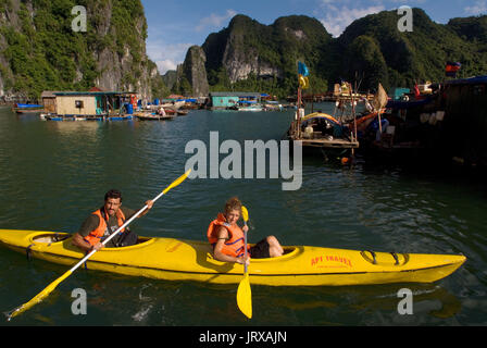 I turisti in vari kayak da un tour in barca nella baia di Halong vietnam. racers canoa kayak da mare nella baia di Halong durante una gara avventura in Vietnam. Foto Stock