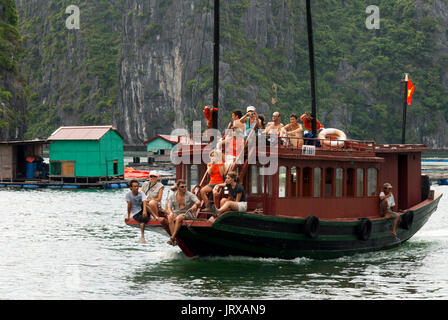 I turisti in giunca Cinese, baia di Halong imbarcazione turistica tour, Vietnam. Posta indesiderata, in barca a vela tra Carso montagne calcaree a cat ba national park, ha long Foto Stock