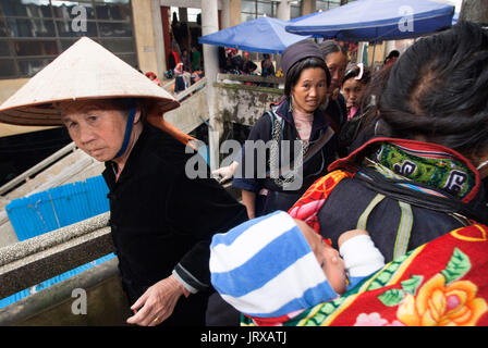 Nero donne hmong fabbricano e vendono artigianato tribale e vestiti iniside il mercato di sapa, lao cai provincia, Vietnam Foto Stock