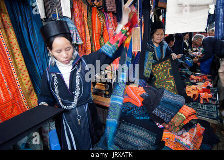 Nero donne hmong fabbricano e vendono artigianato tribale e vestiti iniside il mercato di sapa, lao cai provincia, Vietnam Foto Stock