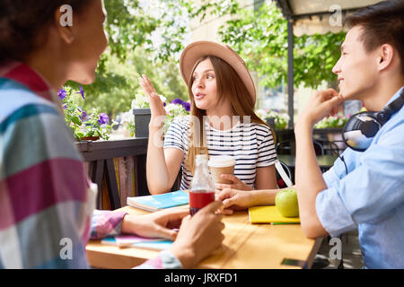 Gli studenti in chat a pranzo in Outdoor Cafe Foto Stock