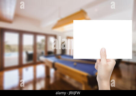 Mano azienda carta bianca con arredamento sfondo sfocato Foto Stock