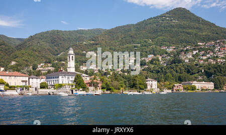 Una vista dal lago sul comune di Cernobbio con chiesa e colline circostanti, Lago di Como, Italia Foto Stock