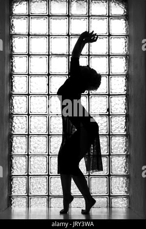 Donna di silhouette con finestra sullo sfondo nei toni del bianco e del nero Foto Stock