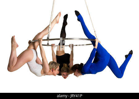 Giovane donna di trio facendo som acrobatici volteggi sull'antenna di lucentezza Foto Stock