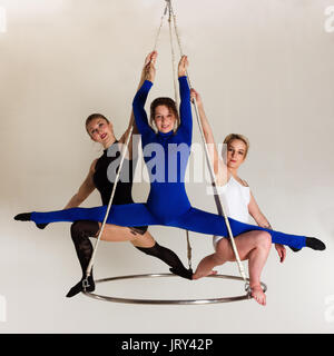 Giovane donna di trio facendo som acrobatici volteggi sull'antenna di lucentezza Foto Stock