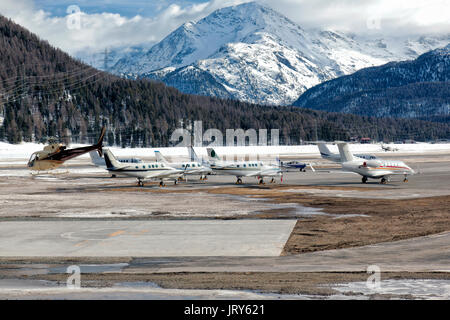 Un elicottero è tenuto spento e jet privati sono parcheggiate nell'aeroporto di St Moritz in Europa Foto Stock