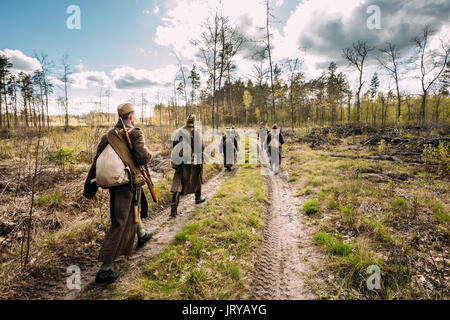 Gruppo di re-enactors vestito come Soviet russo Rosso esercito di soldati di fanteria della II Guerra Mondiale in marcia lungo la strada forestale a stagione primaverile. Foto Stock