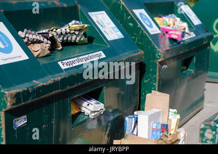 Riciclaggio di verde i contenitori pieni con carta e scatole in corrispondenza di una stazione ambientale in Soderhamn, Svezia - 18 Luglio 2017 Foto Stock