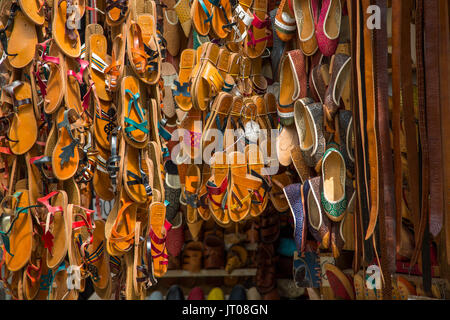 Pantofola in cuoio e sandali per la vendita in negozi. Souk Medina di Fez, Fes el Bali. Il Marocco, Maghreb Nord Africa Foto Stock