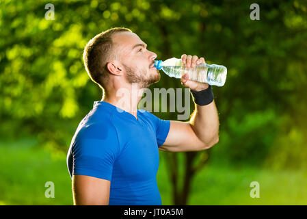 Athletic uomo maturo di bere acqua da una bottiglia Foto Stock