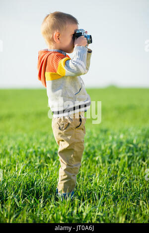 Ragazzino con un vecchio le riprese della telecamera per esterno. Foto Stock