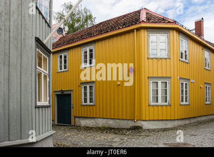 Tradizionale casa in legno con angolo inclinato su una stretta strada di ciottoli nel centro storico. Trondheim, Sør-Trøndelag, Norvegia, Scandinavia, Europa Foto Stock