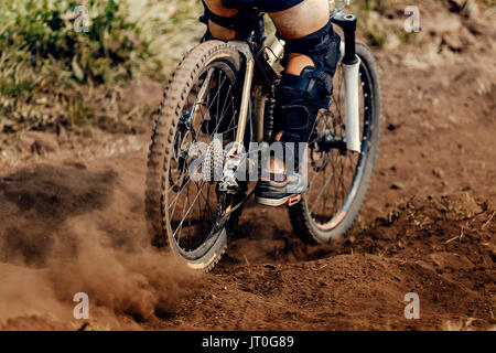 La polvere della ruota posteriore della bicicletta in discesa in mountain bike Foto Stock