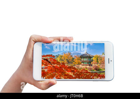 Mano azienda Smartphone con immagine di Gyeongbukgung in autunno, Seoul, Corea del Sud. Foto Stock
