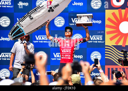 Huntington Beach, Stati Uniti d'America. 06 Agosto, 2017. Kanoa Igarashi (USA) montacarichi il trofeo come ha incoronato il 2017 FURGONI US Open di surf nella sua città natale di Huntington Beach, CA. Credito: Benjamin Ginsberg/Alamy Live News. Foto Stock