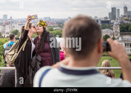 Londra, Regno Unito. Il 7 agosto, 2017.UK Meteo: turisti scattare foto e telefono selfies dalla sommità del parco di Greenwich in nuvoloso pomeriggio di luce. Credito: Guy Corbishley/Alamy Live News Foto Stock