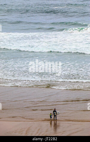 L'uomo mostra ragazzo come il surf, visto dalla Spiaggia indiano sentiero,a Ecola State Park in Oregon, USA. Questa spiaggia è molto popolare tra i surfisti Foto Stock