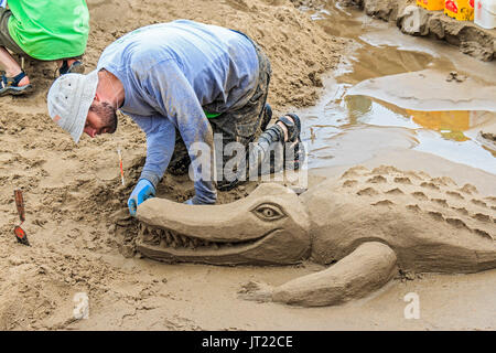 Sandcastle Contest lungo Cannon Beach in Oregon, USA. Le squadre competono per scolpire le scene elaborate di sabbia. Team vincente funziona su Safari di retromarcia Foto Stock