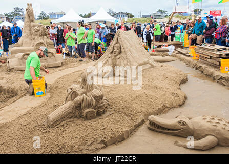 Sandcastle Contest lungo Cannon Beach in Oregon, USA. Le squadre competono per scolpire le scene elaborate di sabbia. Team vincente funziona su Safari di retromarcia Foto Stock