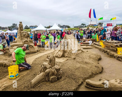 Sandcastle Contest lungo Cannon Beach in Oregon, USA. Le squadre competono per scolpire le scene elaborate di sabbia. Team vincente funziona su Safari di retromarcia Foto Stock