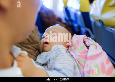 Adorable Baby dormendo su aereo ,Toddler ragazzo dormiva sul padre di giri durante il viaggio in aereo,volare con i bambini. Papà e dormire dieci mesi Foto Stock