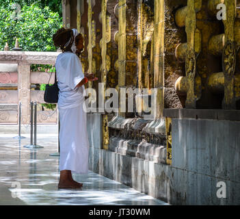 Bodh Gaya, India - Lug 9, 2015. Un uomo indiano pregare al tempio di Mahabodhi a Bodhgaya,, India. Il Mahabodhi Vihar, un sito Patrimonio Mondiale dell'UNESCO, è un Foto Stock