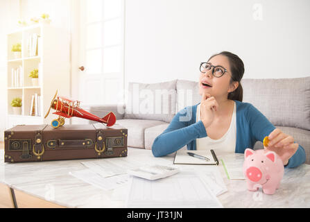 Giovani casalinga risparmiare denaro guardando in alto a immaginare la foto quando si viaggia sperando di avere una vacanza straniera giorno sognando con amante e regularl Foto Stock