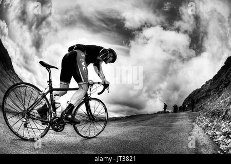 Ciclista in sella fino Hardknott Pass, Cumbria, Regno Unito. Foto Stock