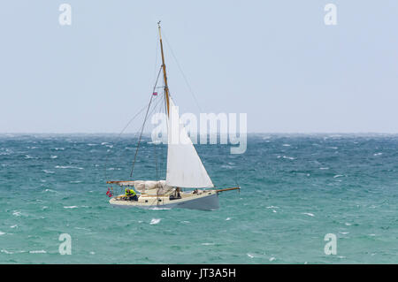 Piccola barca a vela sul mare mosso in una giornata di vento. Piccole barche. Foto Stock
