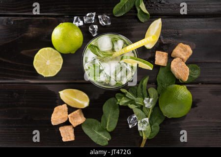 Vista superiore del cocktail mojito in vetro e gli ingredienti più freschi sul legno scuro del tavolo, cocktail concept Foto Stock