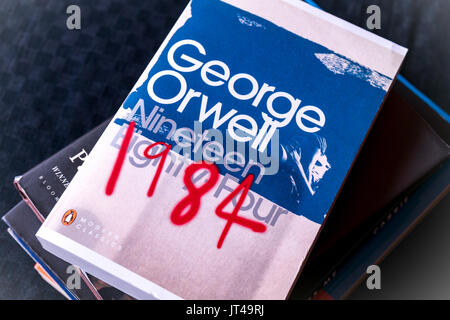 Una copia del classico romanzo bestseller " 1984 " da British autore George Orwell sulla sommità di una pila di libri Foto Stock