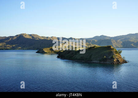 Vista panoramica a Gili Lawa di montagne e colline presso la costa dell'oceano in Flores, Indonesia. Foto Stock