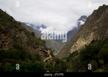 Il cammino Inca in Perù, che conduce attraverso una valle circondata da moody nuvole Foto Stock