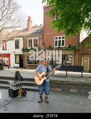 Uomo che indossa maglietta blu e jeans denim, suonare la chitarra elettrica e canto, musicista di strada nella città di York, Inghilterra, Foto Stock