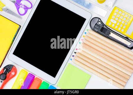 Lay piatto con tavoletta digitale con schermo vuoto e colorato forniture per ufficio isolato su bianco Foto Stock