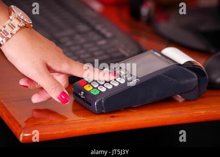 Pagamento moderna con la nuova tecnologia utilizzando una smart watch e premendo alcuni tasti, comprare e vendere prodotti servizio su di un tavolo di legno Foto Stock