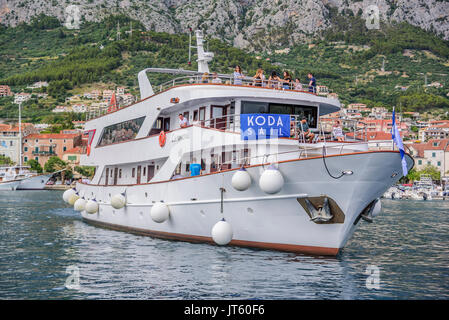 Imbarcazione da diporto con allegro turisti entra nel porto di Makarska, Croazia. Foto Stock