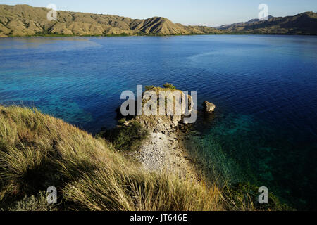 La vista dalla cima di una montagna a Gili Lawa affacciato su altre montagne lungo la costa con il blu turchesi acque dell'oceano in tra in Flores, in Foto Stock