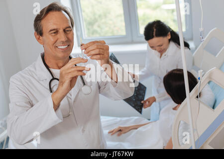 Felice gioiosa medico preparando per una iniezione Foto Stock