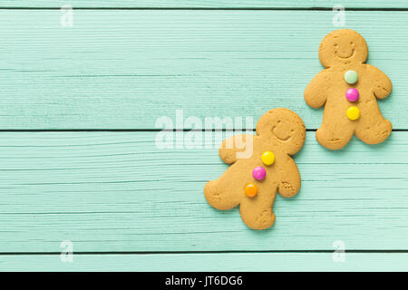Due uomini di panpepato colorati su un tavolo di legno. Vista dall'alto. Xmas gingerbread. Foto Stock