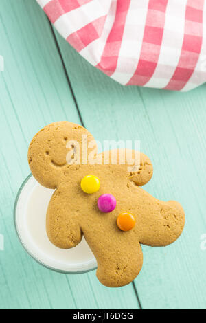 Dolce omino di pan di zenzero e bicchiere di latte sul tavolo di legno. Xmas gingerbread. Foto Stock